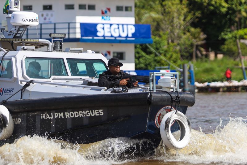 Policial dentro de barco, com arma de fogo em mãos enquanto realiza patrulhamento no rio para redução da criminalidade no baixo Tocantins.