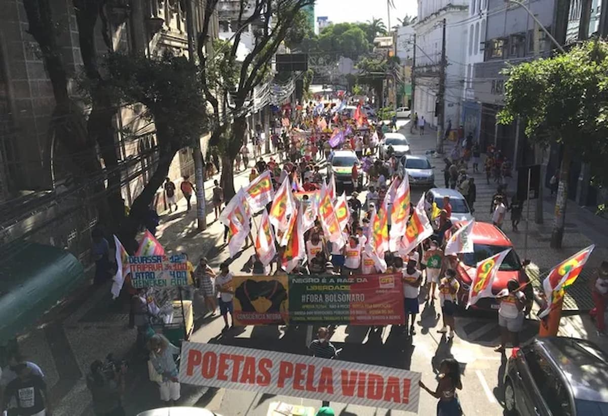 Marcha da consciência negra realizada em 2022 em Salvador. Pessoas na rua com faixas e bandeiras contra o ex-governo Bolsonaro e contra o racismo.