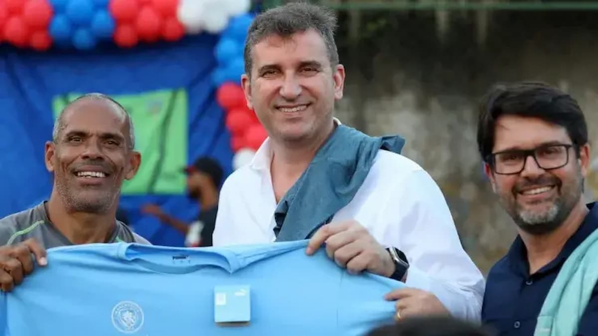 Líderes do clube e do Grupo City segurando uma camisa em celebração a compra do Bahia.