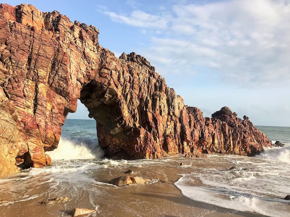 Pedra Furada que foi esculpida pelas ondas do mar sob o céu azul do Ceará