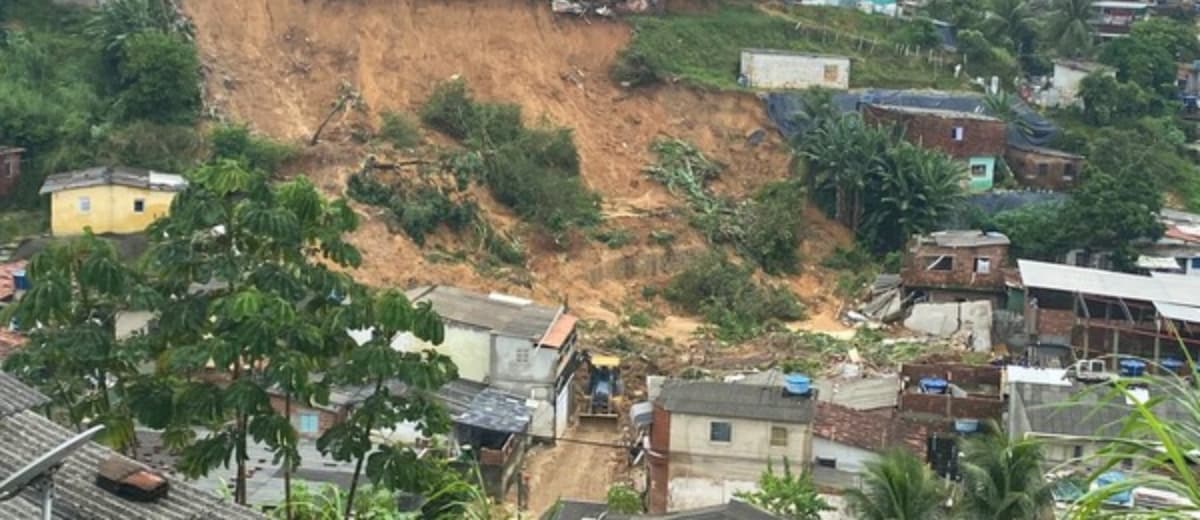 Vista aérea de um dos desastres naturais em Pernambuco, onde vê-se barranco desabado sobre casas.