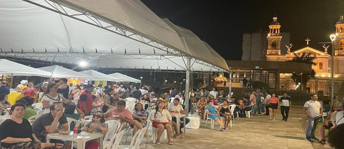 Centenas de pessoas sentadas em cadeira de plástico durante evento religioso em Belém.