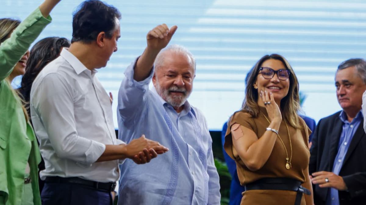 Lula e membros do governo acenando para público.