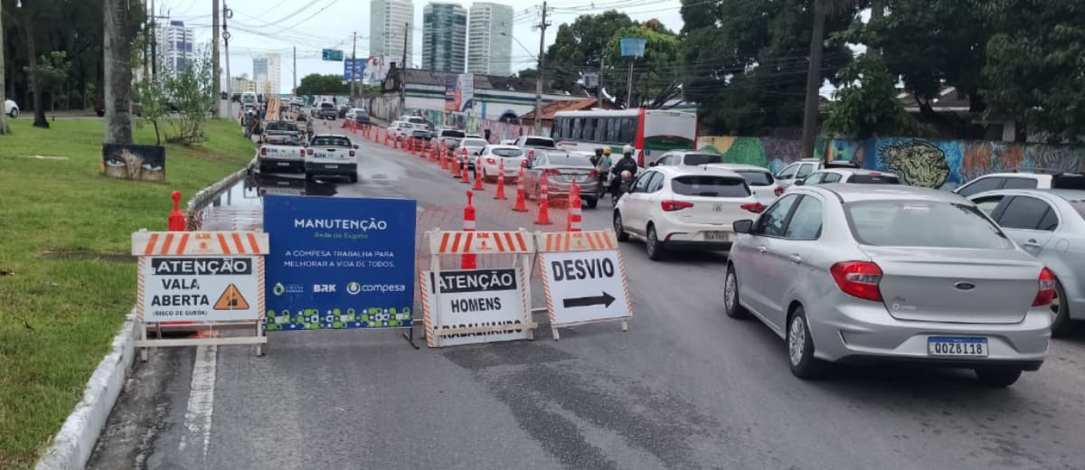 Placas bloqueando parte de uma avenida em Recife para execução de obra emergencial.