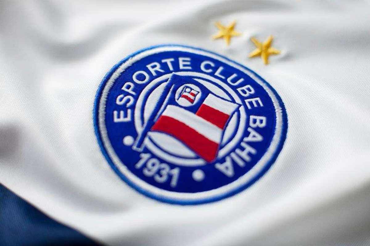 Close up no escudo de uma camiseta branca do Esporte Clube Bahia.